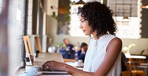 woman using laptop in home kitchen