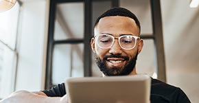 man at home looking at information on tablet